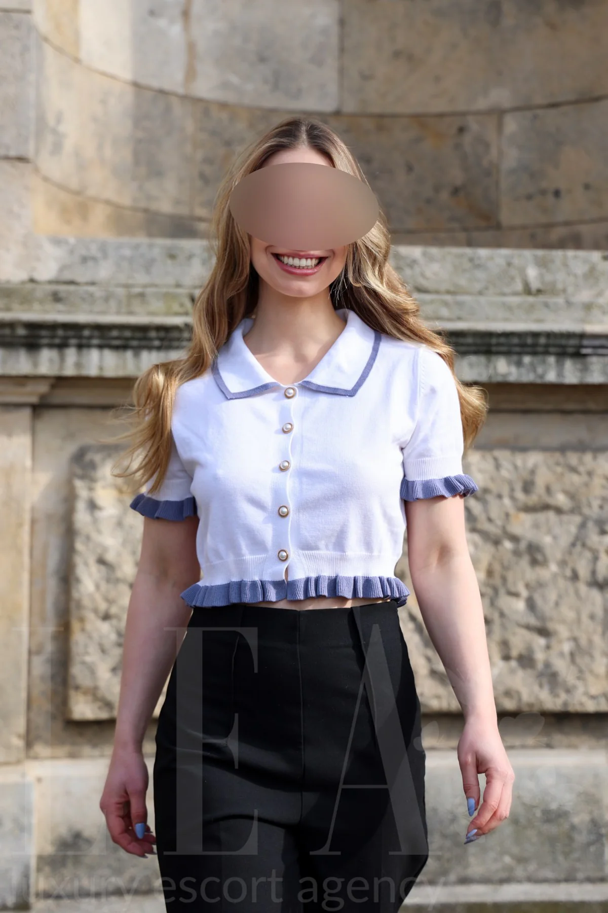 Escort Juna in Bluse und Stoffhose