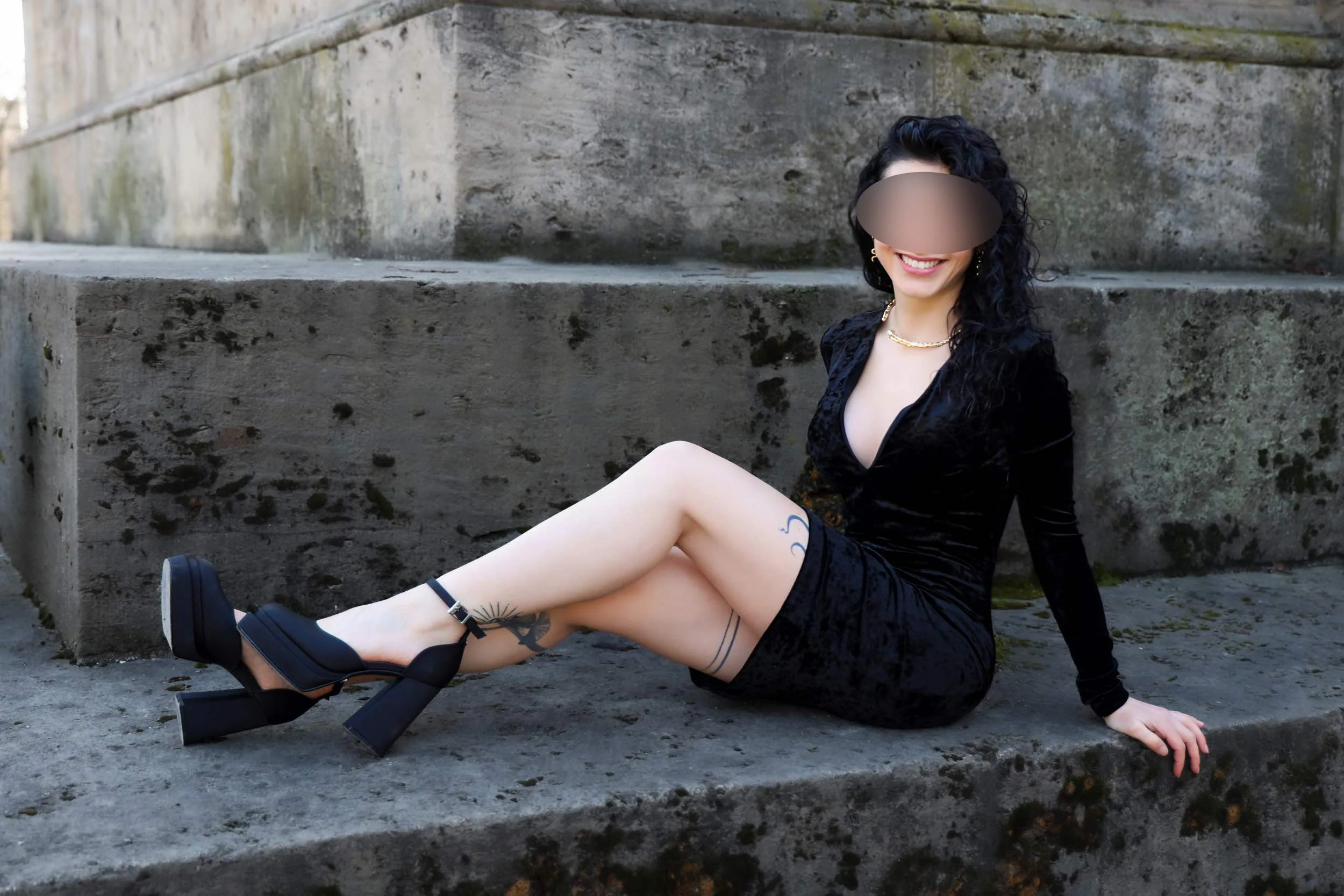 Escort Nora im Samtkleid sitzend in München