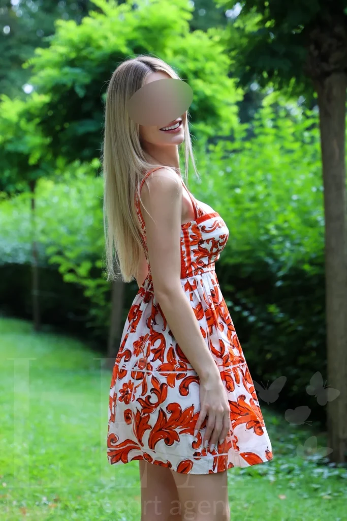 Escort Lady Lilly im Blumenkleid im Park in München