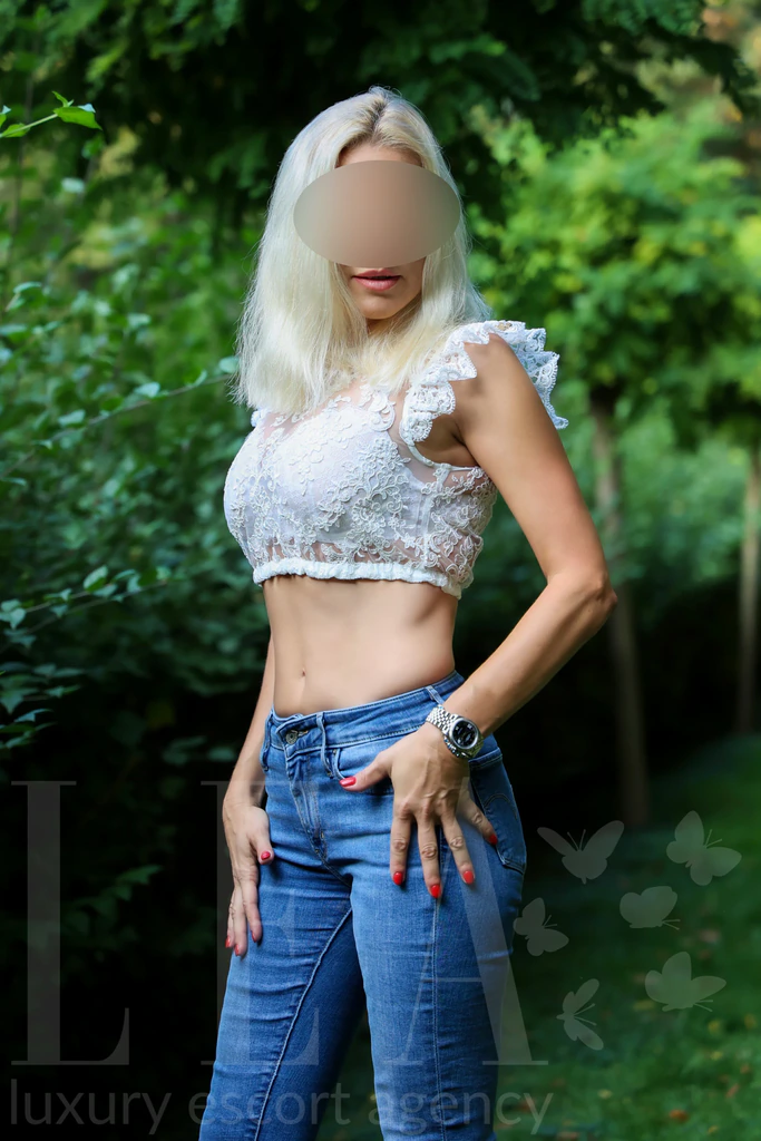 Escort Girl Isabelle in München im weißen Spitzentop mit Jeans