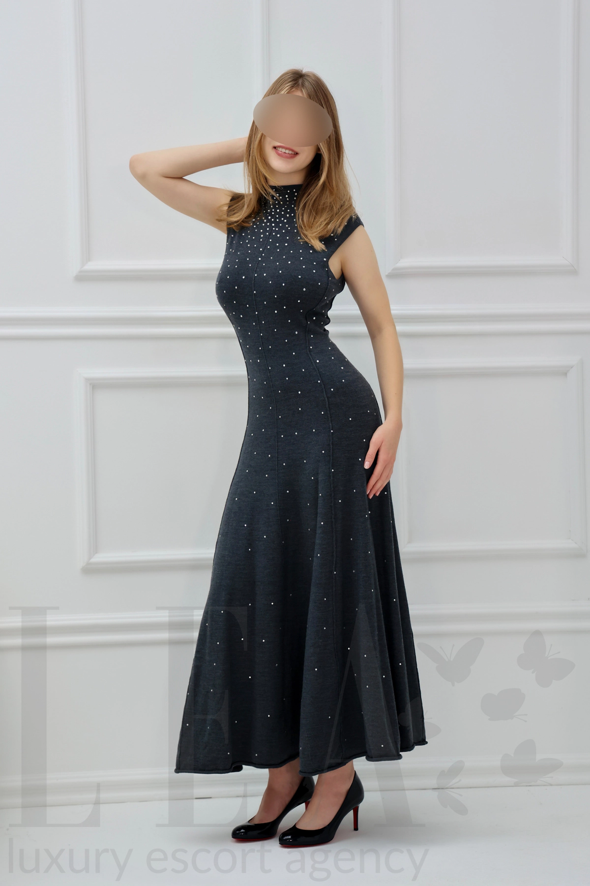 Escort lady Sophia from Berlin in a long grey dress, hand in her hair