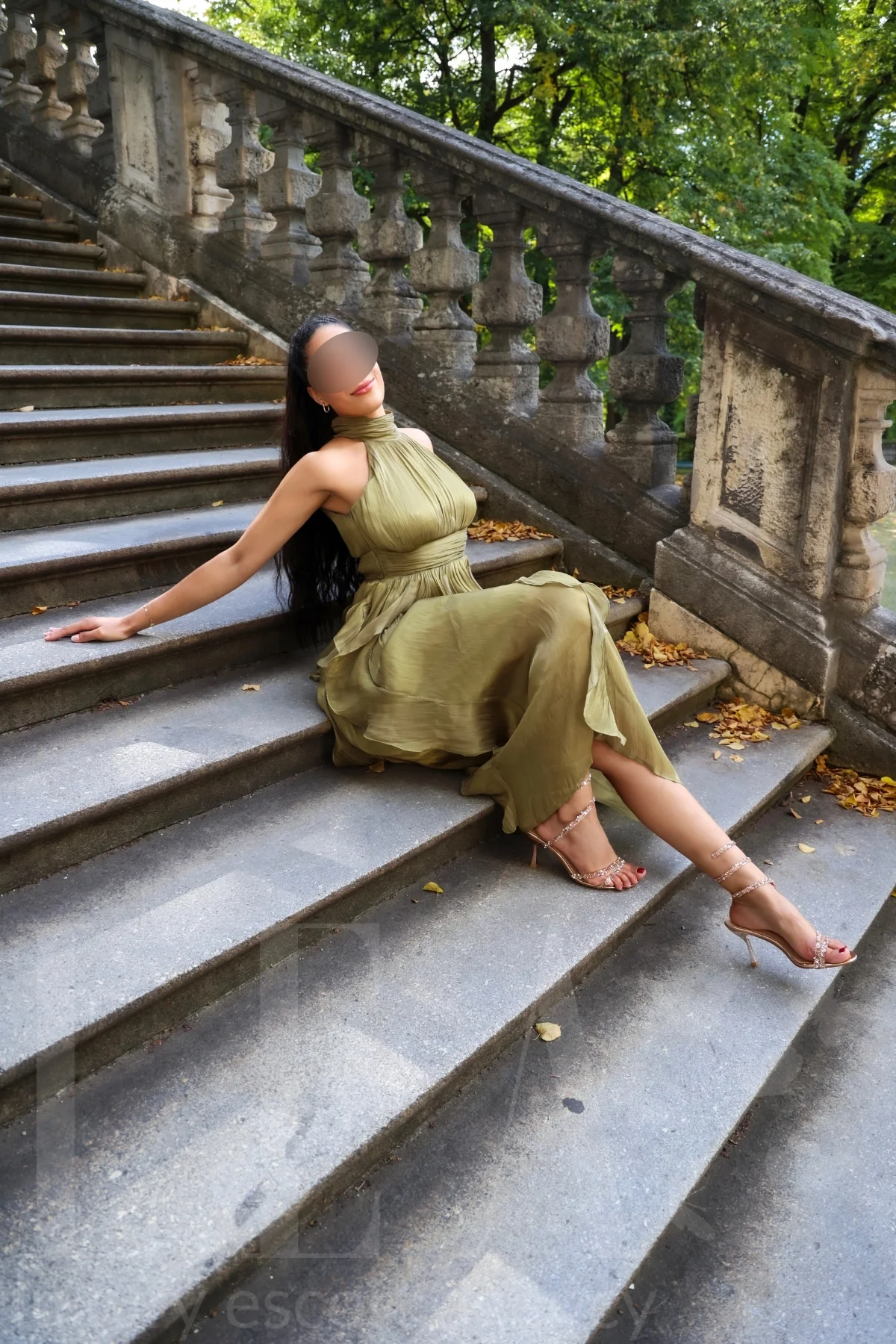 Exklusive Escort Stella aus München im Neckholderkleid auf der Treppe